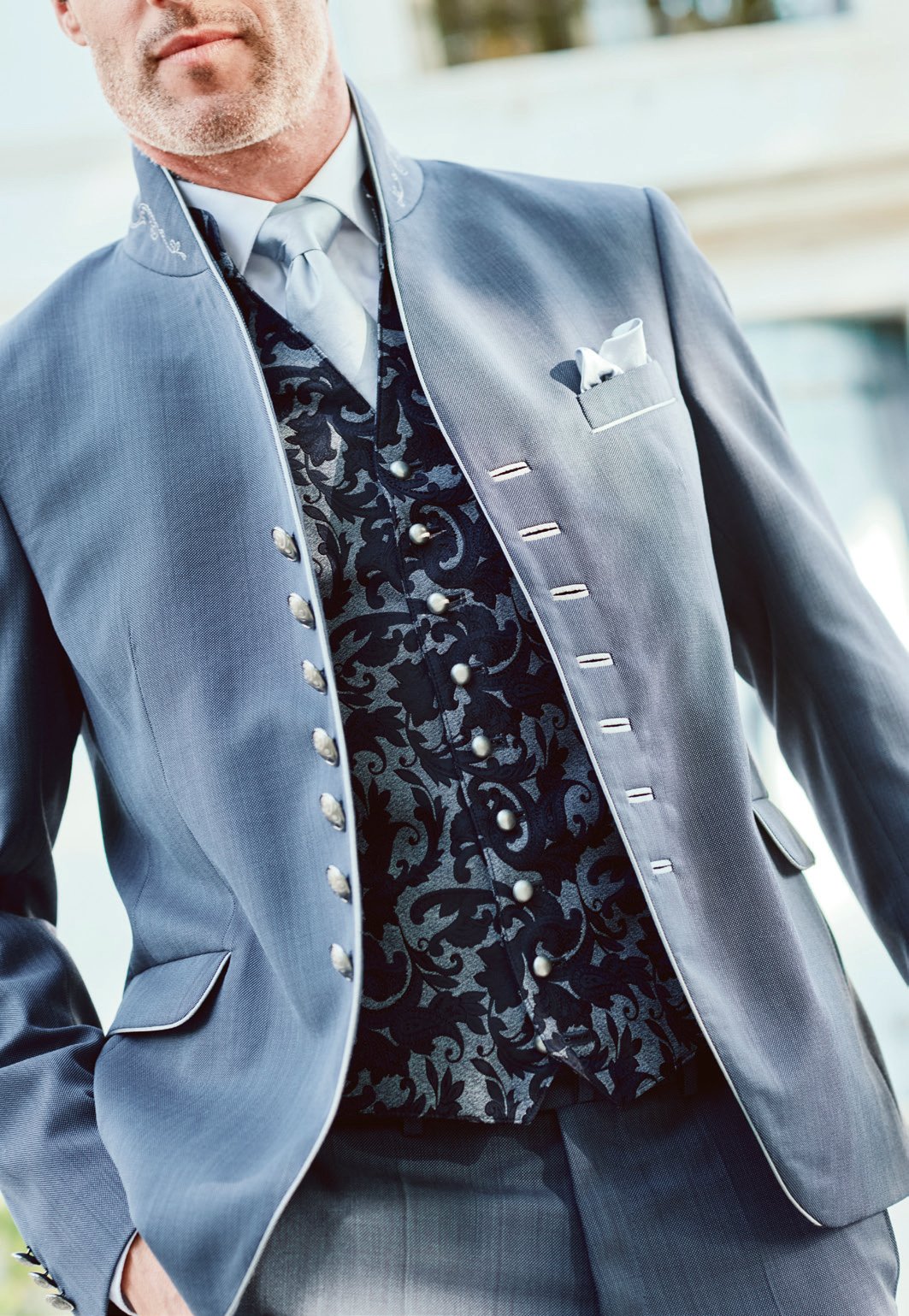 Detailansicht eines stahlblauen Trachtenanzugs mit silberner Brokatweste und Silberknöpfen – Handwerkskunst Wimmer schneidert
