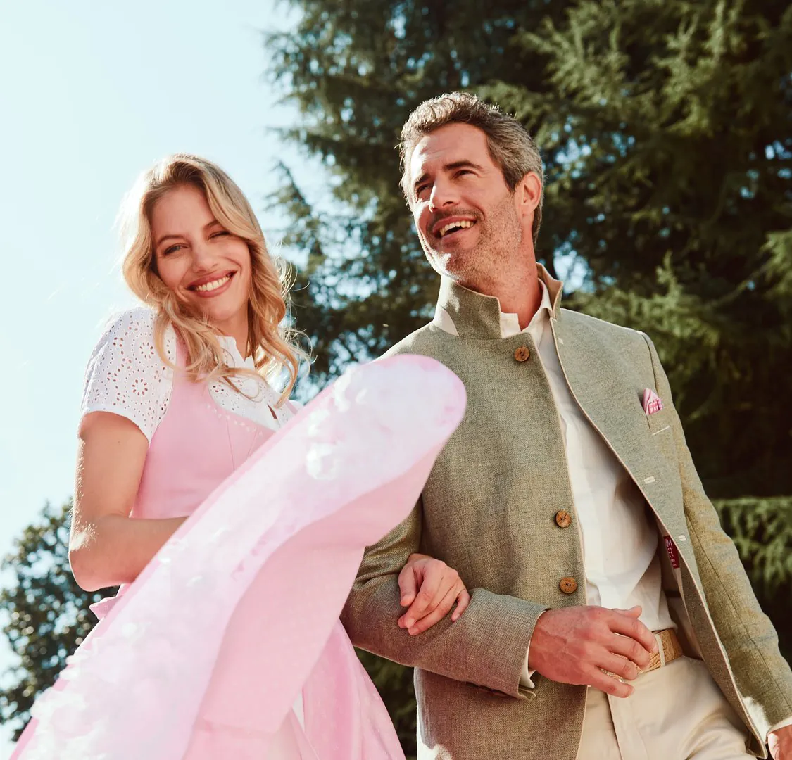 Elegantes Hochzeitspaar in rosa Kleid und beige Anzug beim gemeinsamen Spaziergang