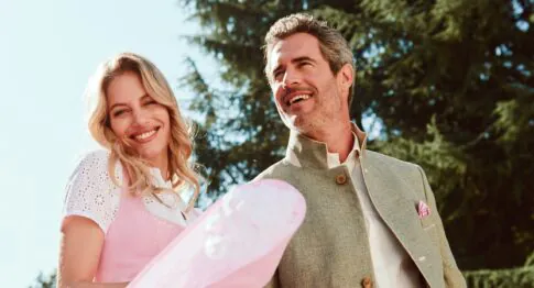 Elegantes Hochzeitspaar in rosa Kleid und beige Anzug beim gemeinsamen Spaziergang