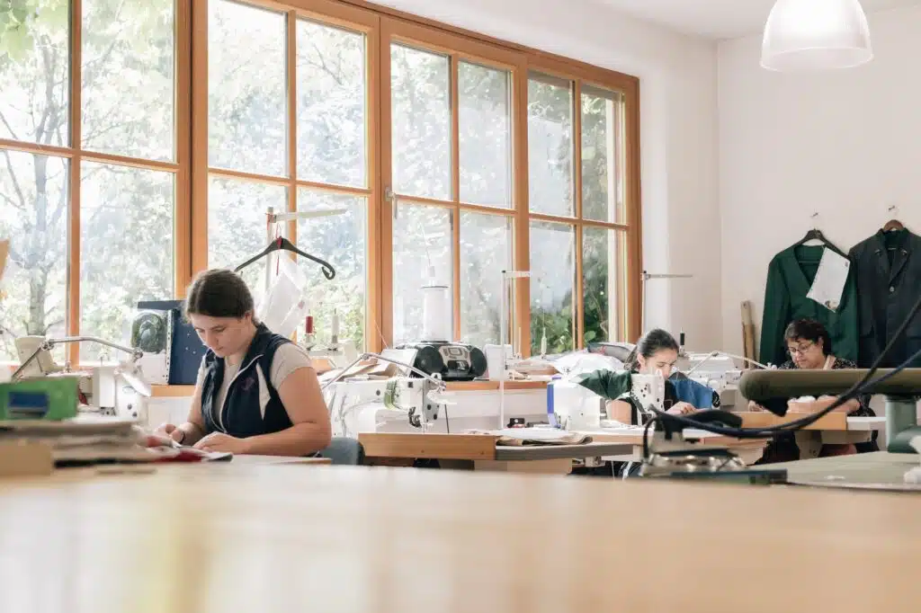 Schneiderinnen arbeiten in der hellen Nähwerkstatt von Wimmer schneidert.